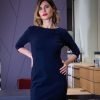 robe marine ou noire portée par une jeune femme debout dans un bureau ou une boutique, manches 3/4