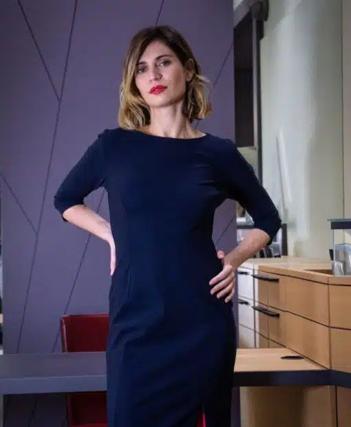 robe marine ou noire portée par une jeune femme debout dans un bureau ou une boutique, manches 3/4