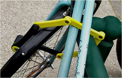 cadenas pliant fixant le cadre du vélo et la roue avant à un arceau à vélo